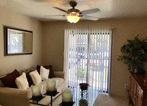 a living room with a couch and a ceiling fan